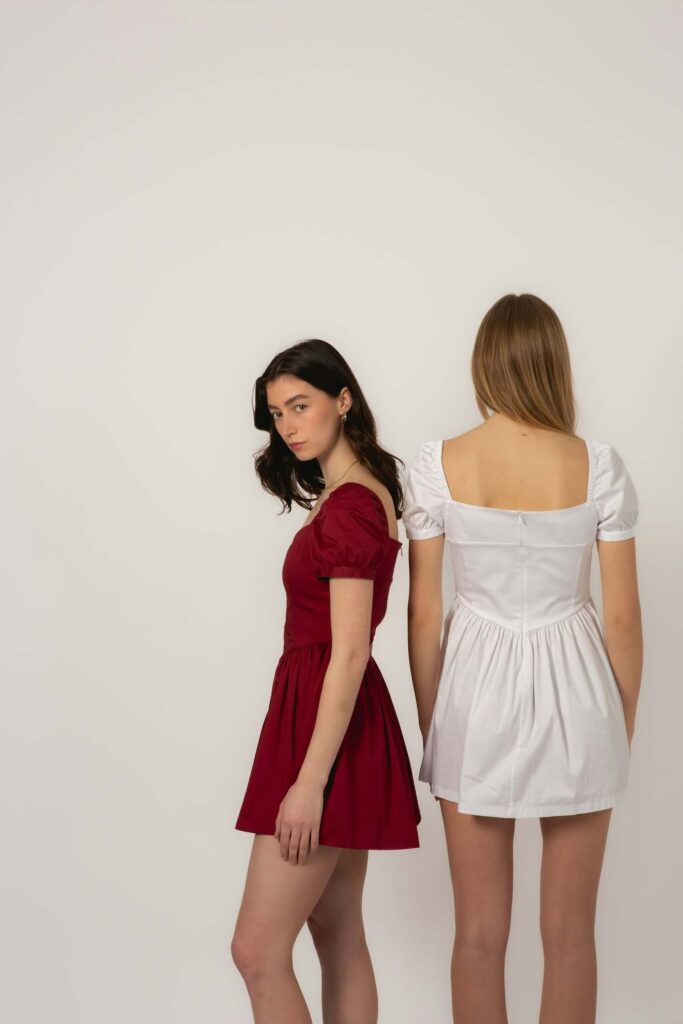 Två kvinnliga fotomodeller poserar i profil och med ryggen mot kameran – exempelbild för modelltest.
